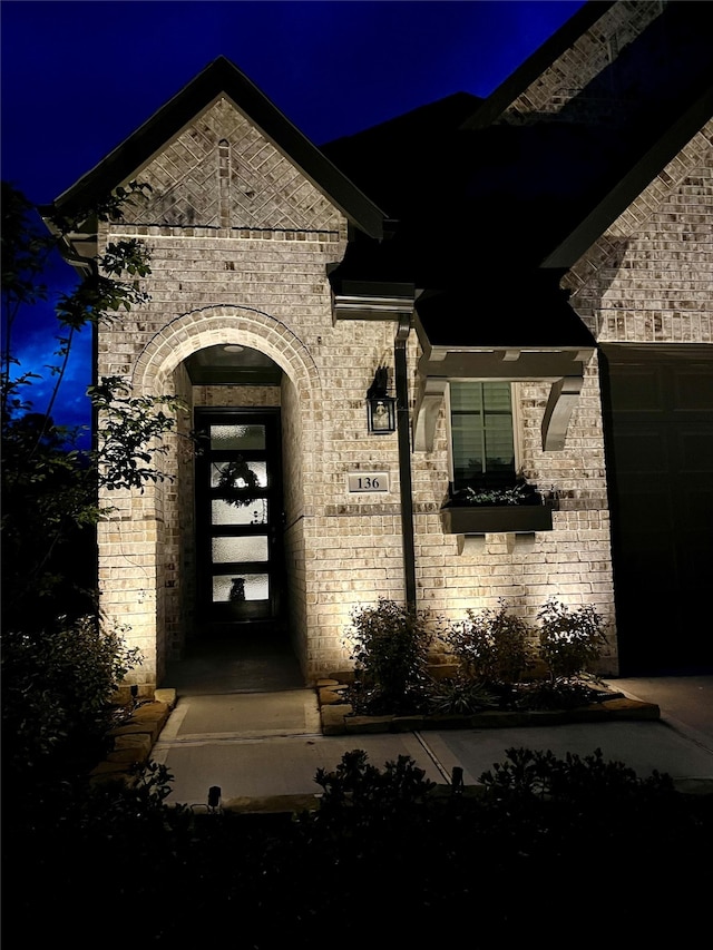 view of exterior entry at twilight