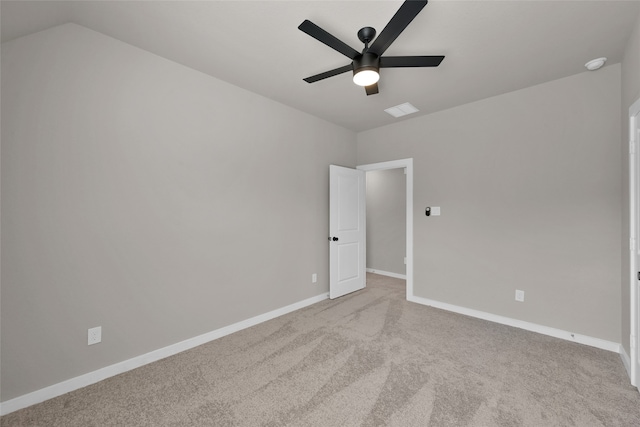 carpeted spare room with ceiling fan and vaulted ceiling