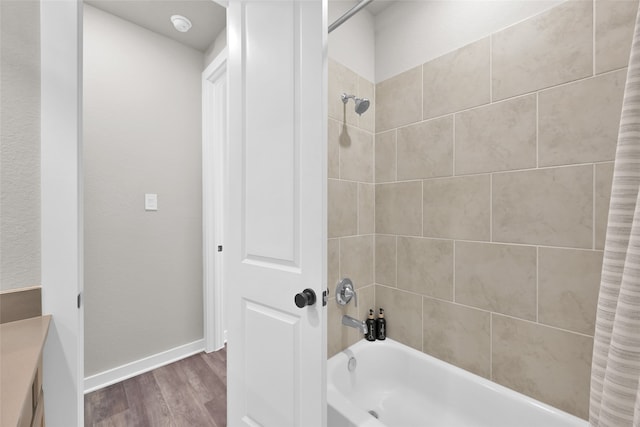 bathroom with shower / tub combo with curtain and hardwood / wood-style flooring