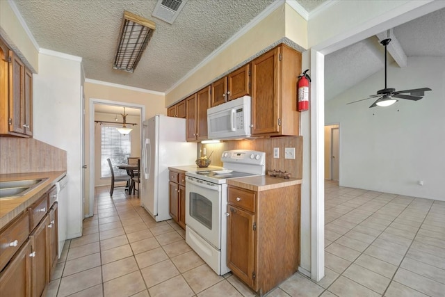 kitchen featuring a textured ceiling, vaulted ceiling with beams, light tile patterned flooring, and white appliances