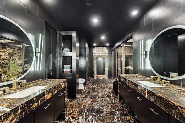 bathroom featuring tile walls, vanity, and toilet