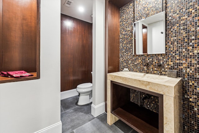 bathroom with vanity, toilet, and decorative backsplash