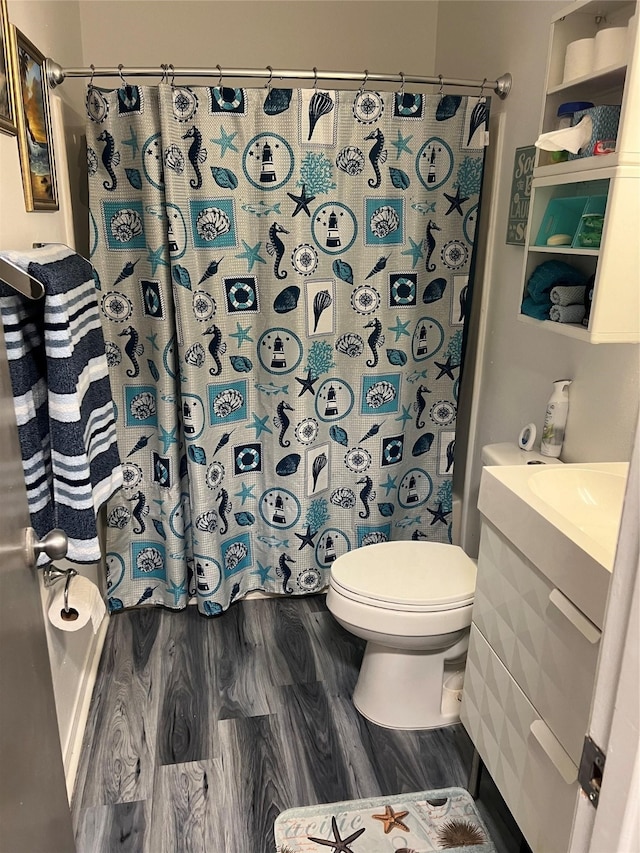 bathroom featuring curtained shower, wood-type flooring, vanity, and toilet