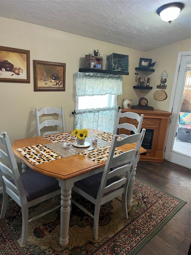 dining area with dark hardwood / wood-style flooring and a textured ceiling