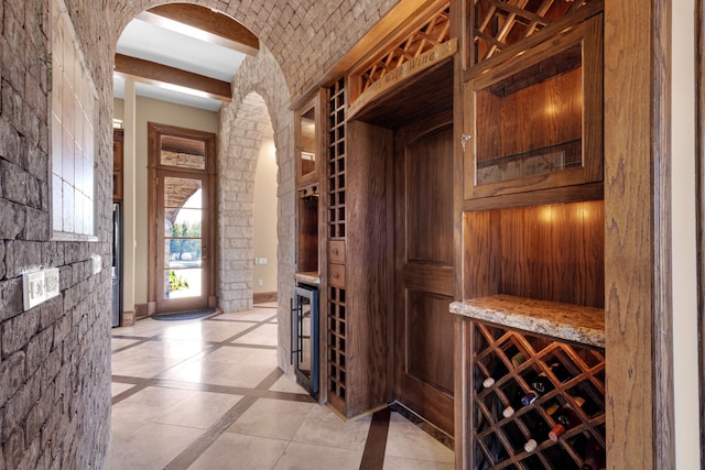 wine room featuring beamed ceiling and light tile patterned floors