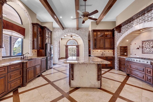 4 Steven Luke Ln, Friendswood, TX 77546 - kitchen featuring inlaid floor details, a ceiling fan, arched walkways, a sink, and beam ceiling
