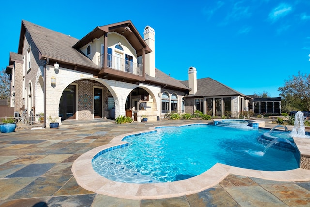 view of pool featuring pool water feature, an in ground hot tub, and a patio area