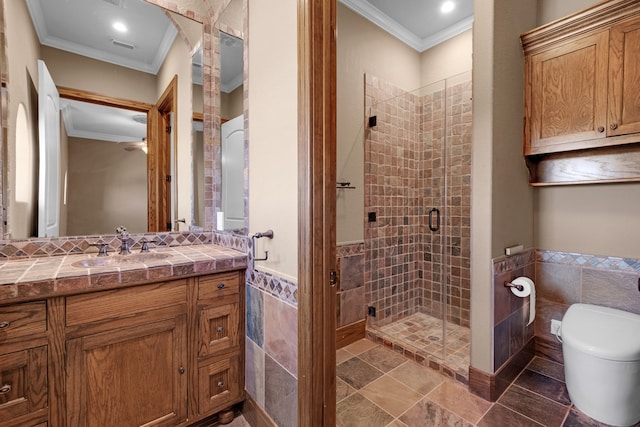 bathroom featuring tile walls, ornamental molding, vanity, and a shower with shower door