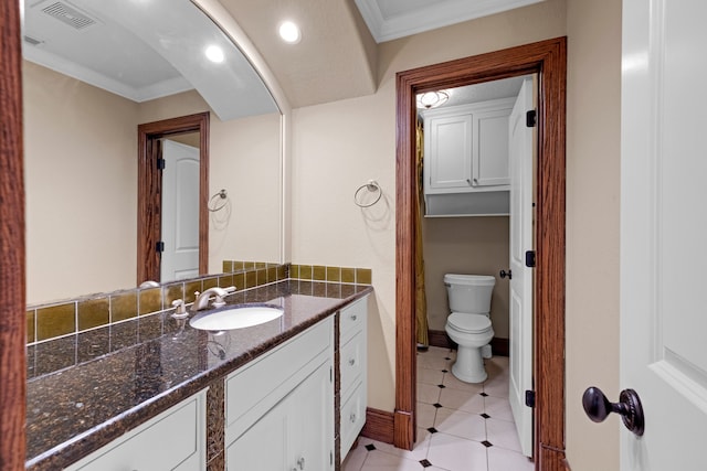 bathroom with toilet, vanity, tile patterned flooring, and crown molding