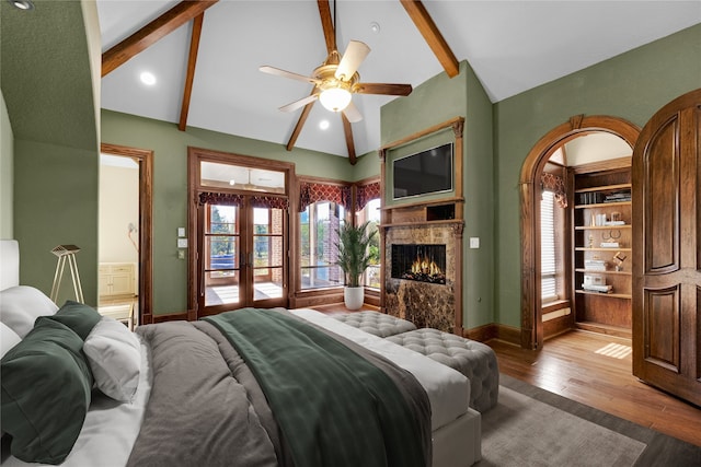 bedroom with lofted ceiling with beams, multiple windows, and light hardwood / wood-style flooring