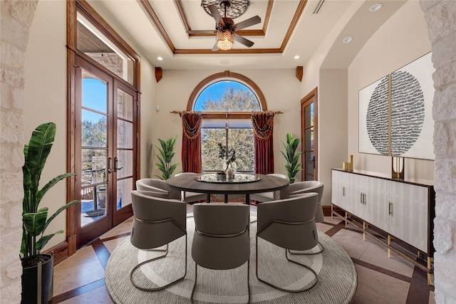 dining area featuring ceiling fan, french doors, a healthy amount of sunlight, and a raised ceiling