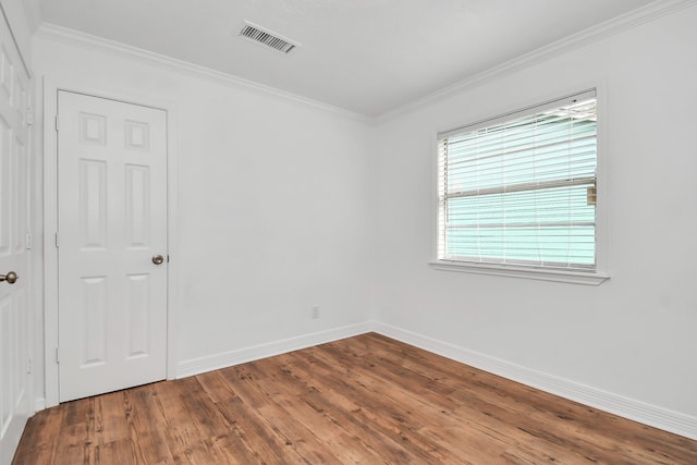 unfurnished room with ornamental molding and hardwood / wood-style floors