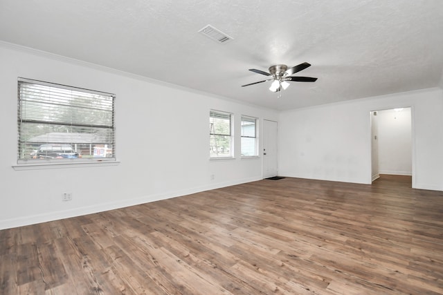 empty room with ceiling fan, dark hardwood / wood-style floors, a textured ceiling, and ornamental molding