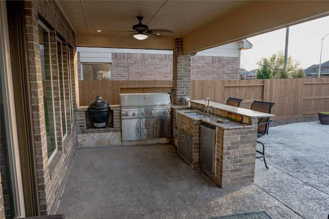 view of patio with an outdoor kitchen, area for grilling, sink, and ceiling fan