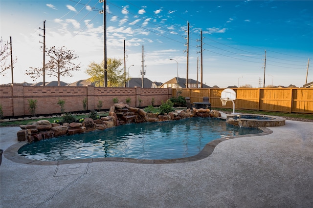 view of swimming pool featuring pool water feature and an in ground hot tub