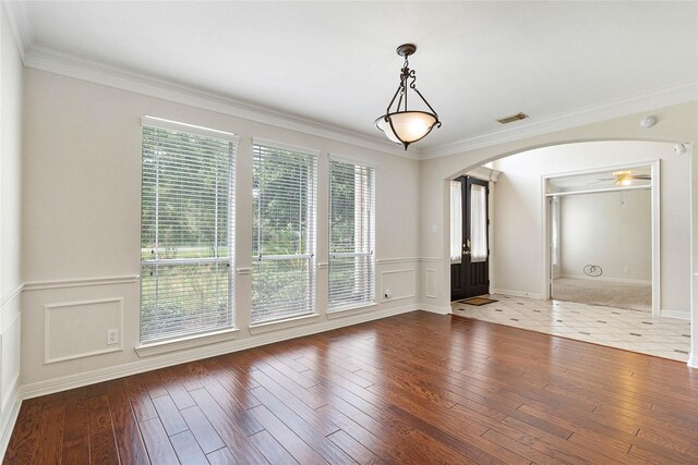 unfurnished room featuring crown molding, hardwood / wood-style floors, and a healthy amount of sunlight