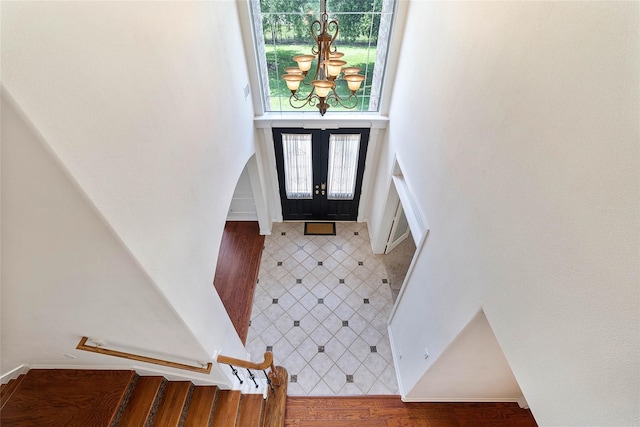 entryway featuring wood-type flooring, an inviting chandelier, and french doors