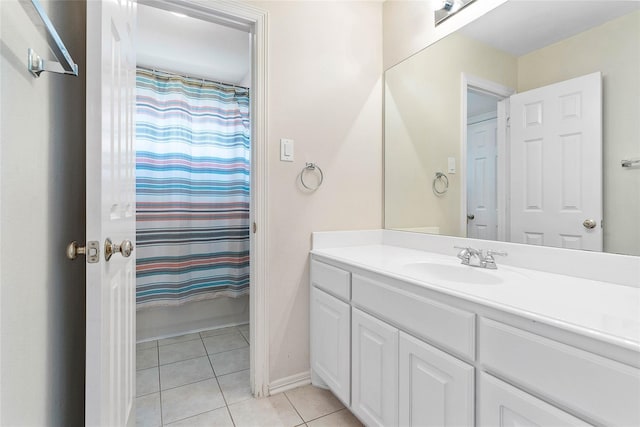 bathroom featuring baseboards, vanity, a shower with shower curtain, and tile patterned floors