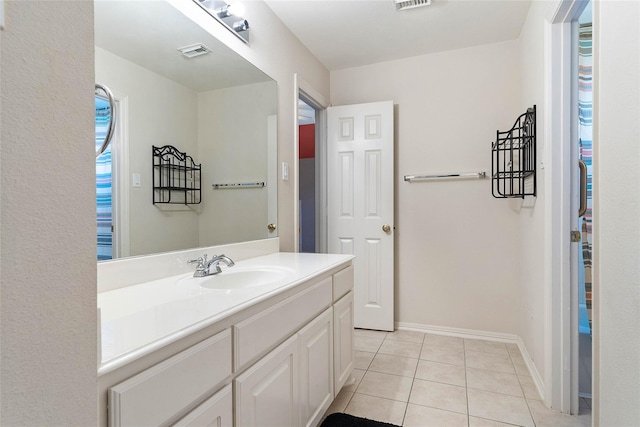 bathroom featuring visible vents, vanity, baseboards, and tile patterned floors