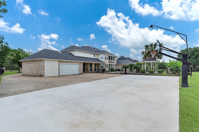 view of side of home with concrete driveway, brick siding, a lawn, and an attached garage