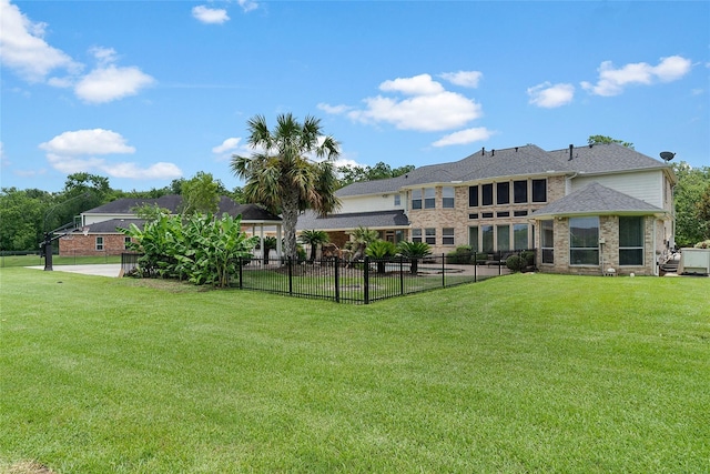 back of property featuring brick siding, a lawn, and fence