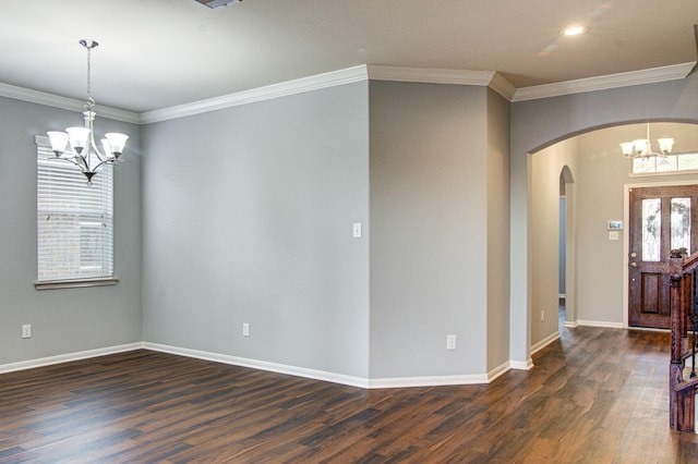 entrance foyer with dark hardwood / wood-style flooring, ornamental molding, and an inviting chandelier