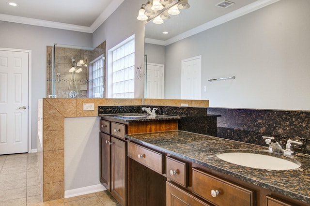 bathroom featuring tile patterned floors, vanity, crown molding, and tiled shower