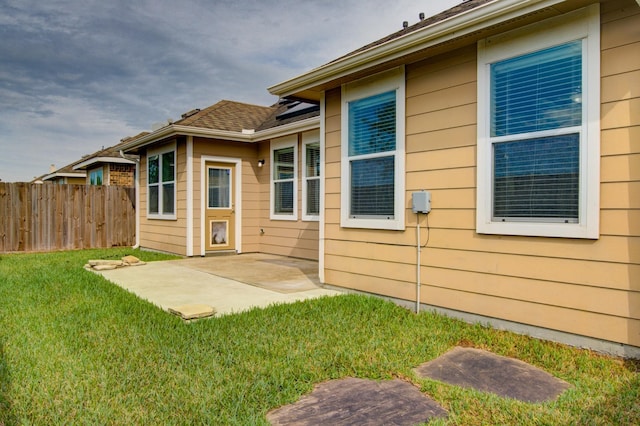 back of property with a yard and a patio