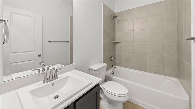 full bathroom featuring toilet, tiled shower / bath combo, and vanity