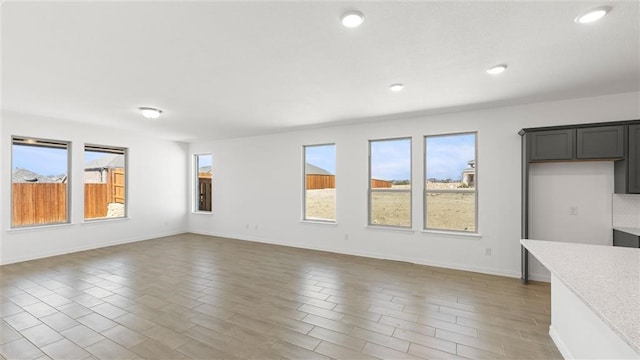 unfurnished living room with hardwood / wood-style floors and a wealth of natural light