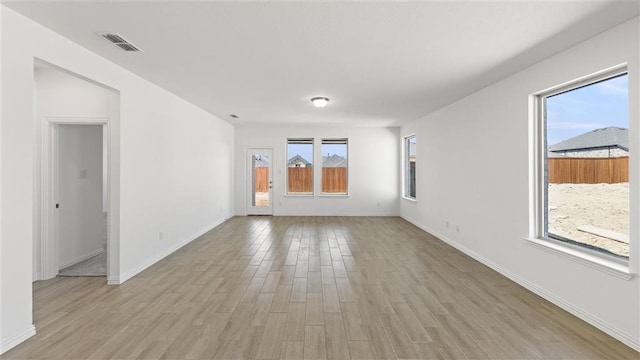 spare room featuring light hardwood / wood-style floors and plenty of natural light