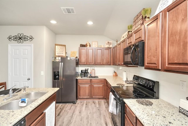 kitchen featuring black appliances, tasteful backsplash, light wood-type flooring, sink, and vaulted ceiling