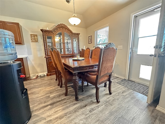 dining space with light wood-type flooring and vaulted ceiling