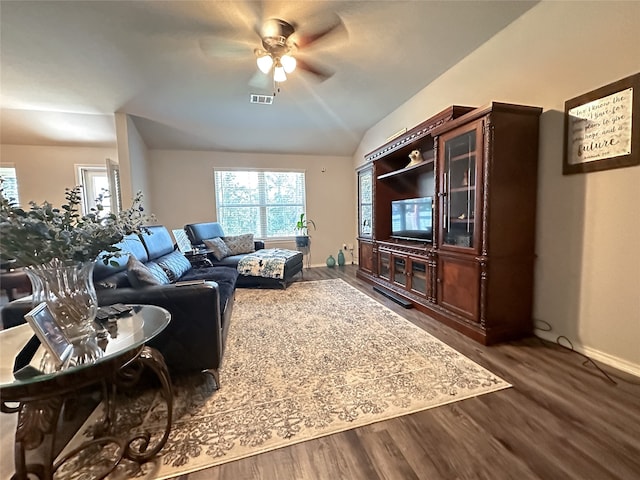 living room featuring ceiling fan, dark hardwood / wood-style floors, and vaulted ceiling