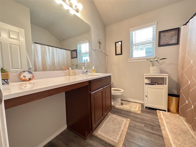 bathroom featuring toilet, vanity, hardwood / wood-style floors, and vaulted ceiling