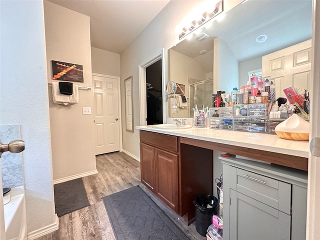 bathroom featuring wood-type flooring, plus walk in shower, and vanity