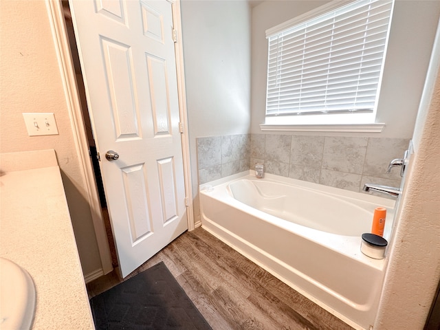 bathroom with hardwood / wood-style flooring, vanity, and a bathing tub