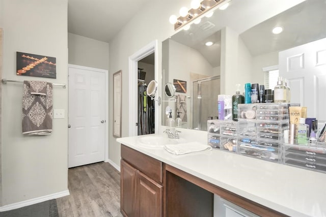 bathroom with wood-type flooring, vanity, a shower with door, and lofted ceiling