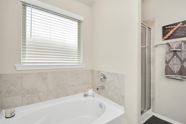 bathroom with a healthy amount of sunlight and separate shower and tub