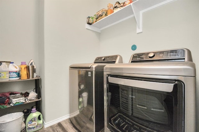 clothes washing area featuring wood-type flooring and washer and dryer