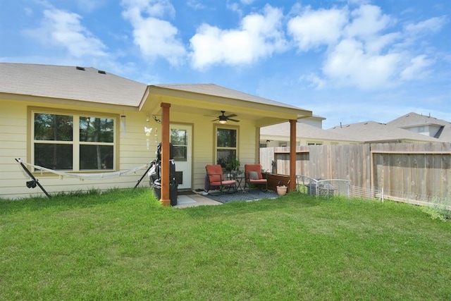 back of property with a patio, ceiling fan, and a yard