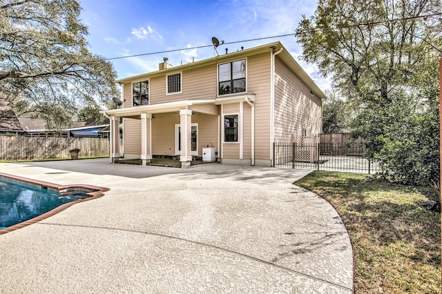 back of house with a fenced in pool and a patio