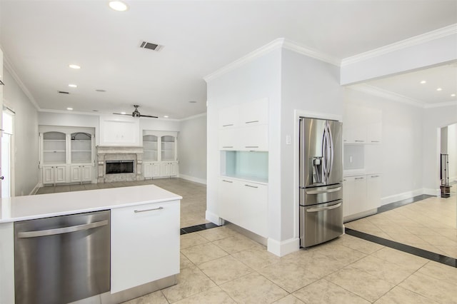 kitchen featuring white cabinets, ceiling fan, light tile patterned floors, and stainless steel appliances