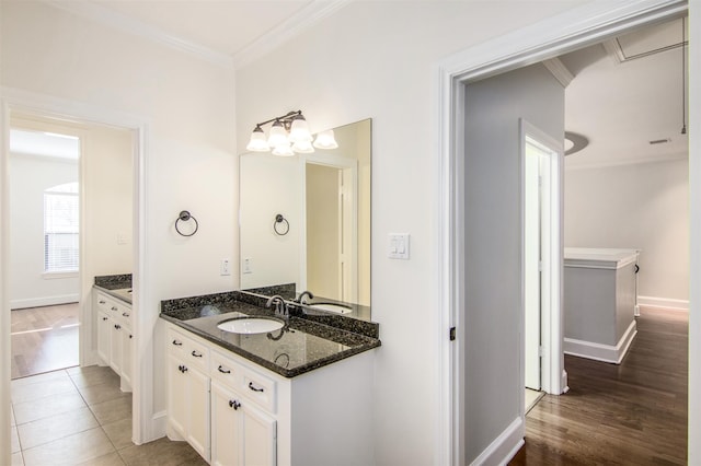 bathroom with tile patterned flooring, vanity, crown molding, and a notable chandelier