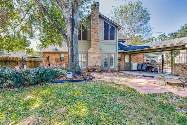 back of property with a yard and a patio