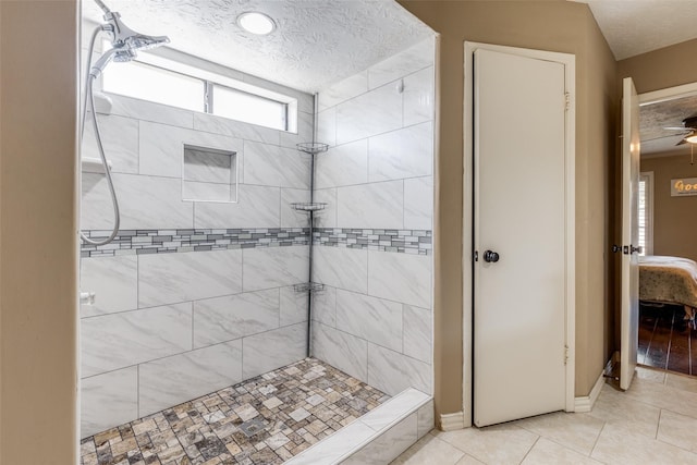 bathroom featuring tile patterned flooring, a textured ceiling, and a tile shower