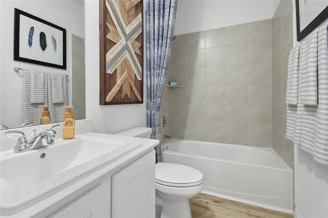 full bathroom with hardwood / wood-style flooring, vanity, toilet, and shower / tub combo