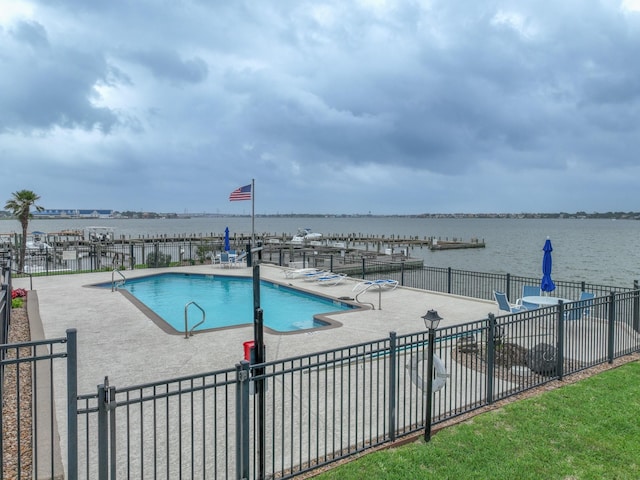 view of pool with a patio and a water view