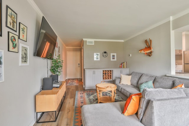 living room with light hardwood / wood-style flooring and crown molding