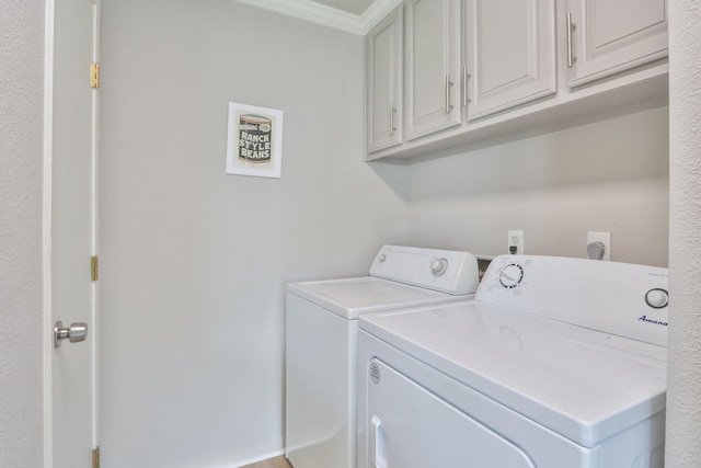 clothes washing area featuring washing machine and dryer, cabinets, and crown molding